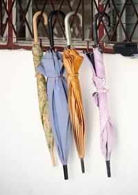 Umbrellas hanging on metal grate at window