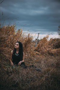 Portrait of young woman standing on field