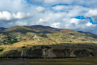 Scenic view of field and mountains against sky