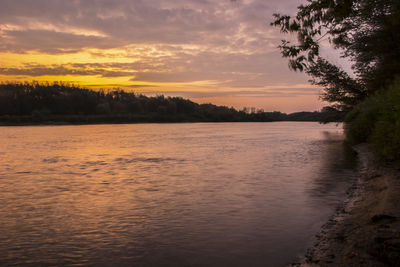 Scenic view of lake against sky at sunset