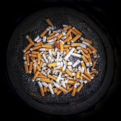Directly above shot of cigarette smoking in container