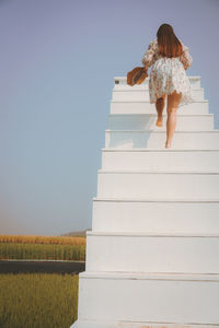 Rear view of woman standing against sky