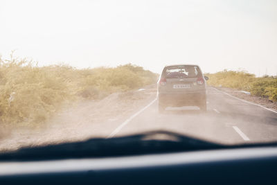 Car on road seen through windshield