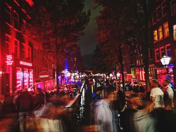 People on illuminated street at night
