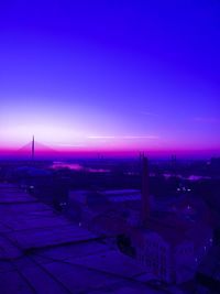 High angle view of illuminated buildings against blue sky at sunset