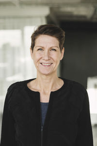 Portrait of confident smiling businesswoman standing at office