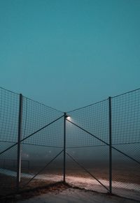 Fence against clear blue sky