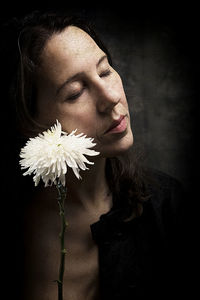 Woman in melancholic attitude with white chrysanthemum x