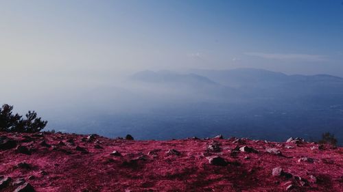 Scenic view of land and mountains against sky