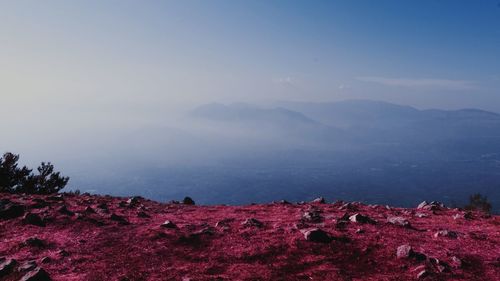 Scenic view of land and mountains against sky