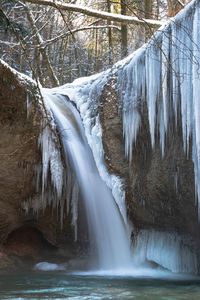 Scenic view of waterfall in forest during winter