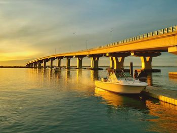 Bridge over river against sky during sunset