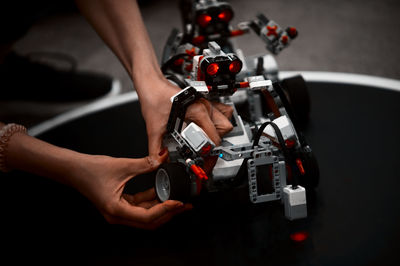 Cropped hands of woman making robot at home