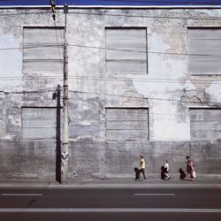 People walking on sidewalk by building