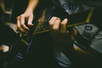 Midsection of man playing guitar