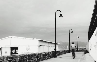 Man walking on road against sky