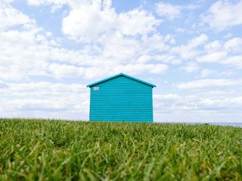 Lifeguard hut on field against sky
