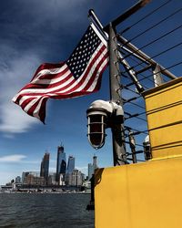 Low angle view of flag by building against sky