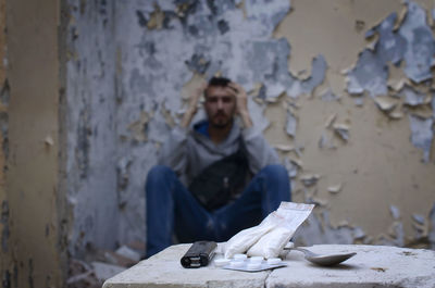 Portrait of man sitting against wall