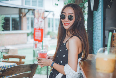 Portrait of a young woman drinking glass