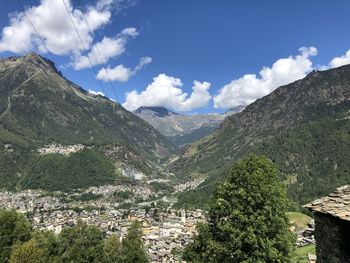 Scenic view of townscape and mountains against sky