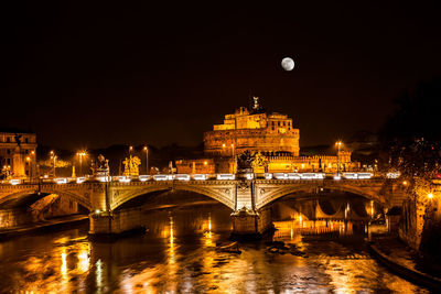 Illuminated bridge over river at night