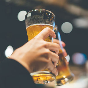 Close-up of hand holding beer glass