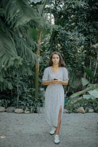 A front view of a young woman using her phone. texting with friends