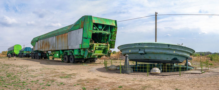 Abandoned train on field against sky