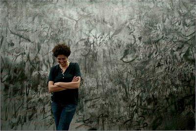 Portrait of a young man standing on tree trunk