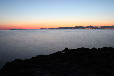 Scenic view of sea against clear sky during sunset