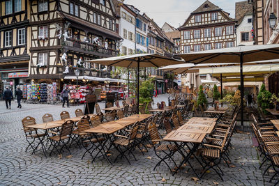 People on sidewalk cafe by buildings in city