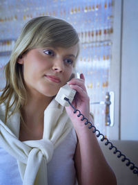 Close-up of mid adult woman using telephone at home