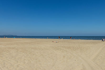 Scenic view of beach against clear blue sky