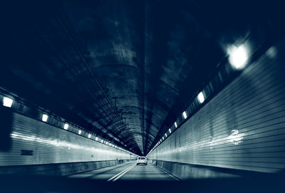Low angle view of illuminated tunnel at night