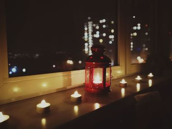 Close-up of illuminated candles on table