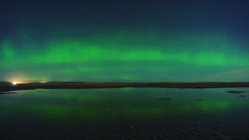 Scenic view of lake against sky at night