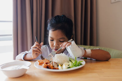 Young woman having food at home