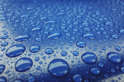 Full frame shot of raindrops on blue water
