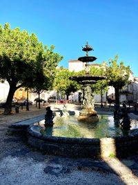 Fountain in park against clear blue sky