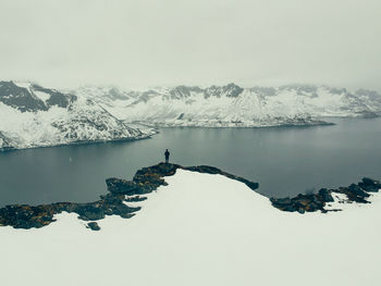 Scenic view of lake by snowcapped mountains against sky