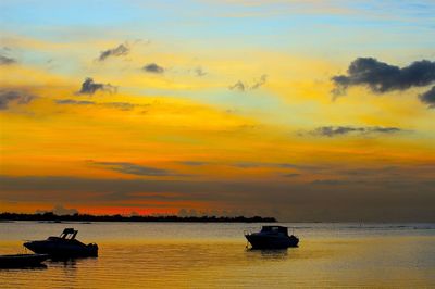 Silhouette boat in sea against sky during sunset