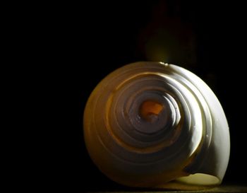 Close-up of glass jar on table against black background