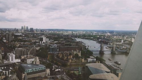 Aerial view of cityscape against cloudy sky