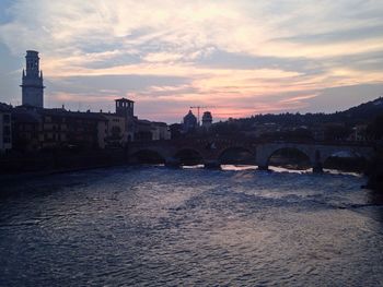 River by city against sky during sunset