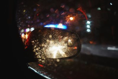 Close-up of illuminated cars on car windshield at night