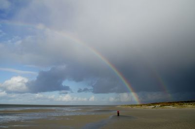 Scenic view of rainbow over sea against sky