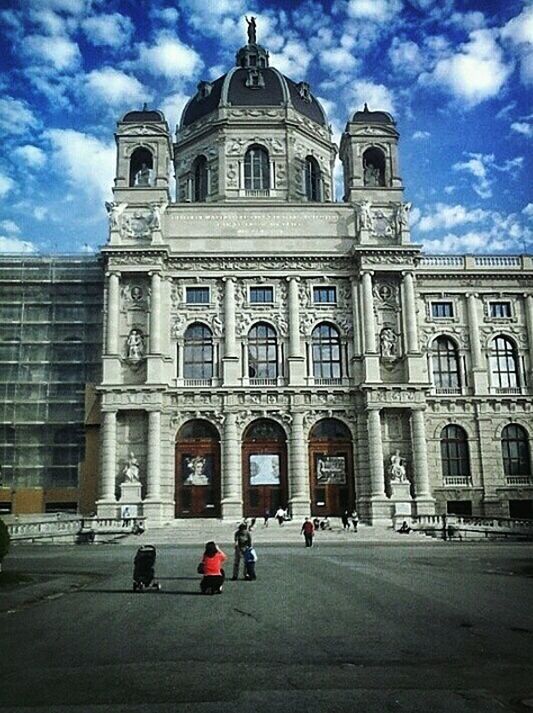 PEOPLE IN FRONT OF CATHEDRAL AGAINST SKY