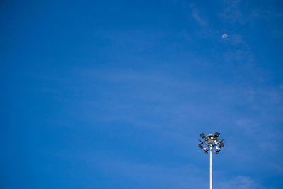 Low angle view of floodlight against blue sky