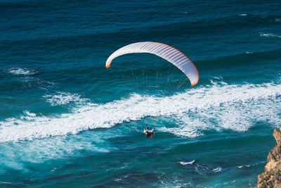 Rear view of man paragliding over sea
